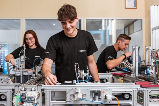 Lherlinge der Siemens Austria bei der Arbeit an verschiedenen technischen Geräten